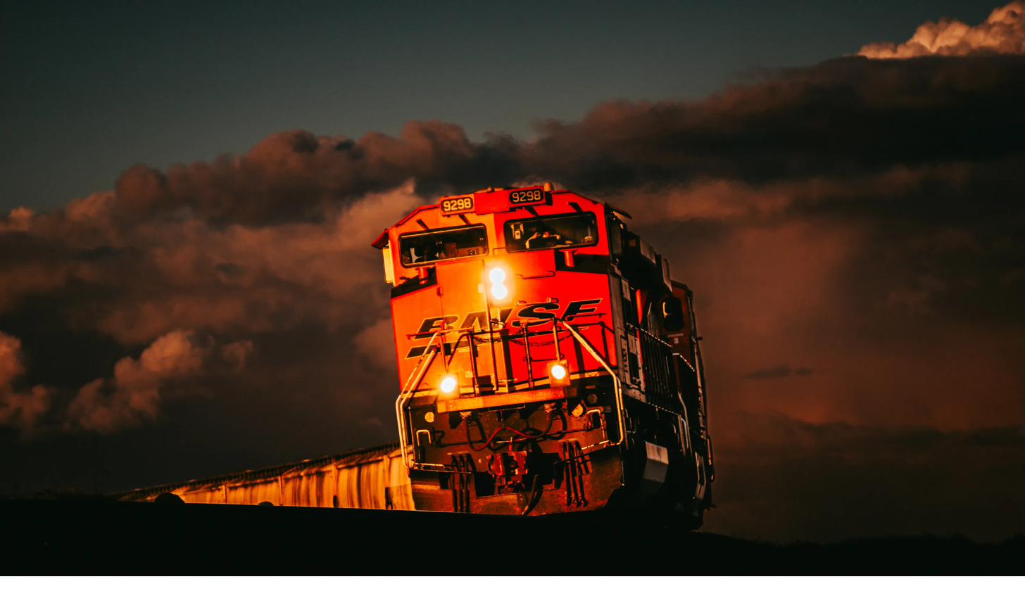 BNSF 9298 bearing down under a cathedral of storm cloud, lit amber by the last of the light