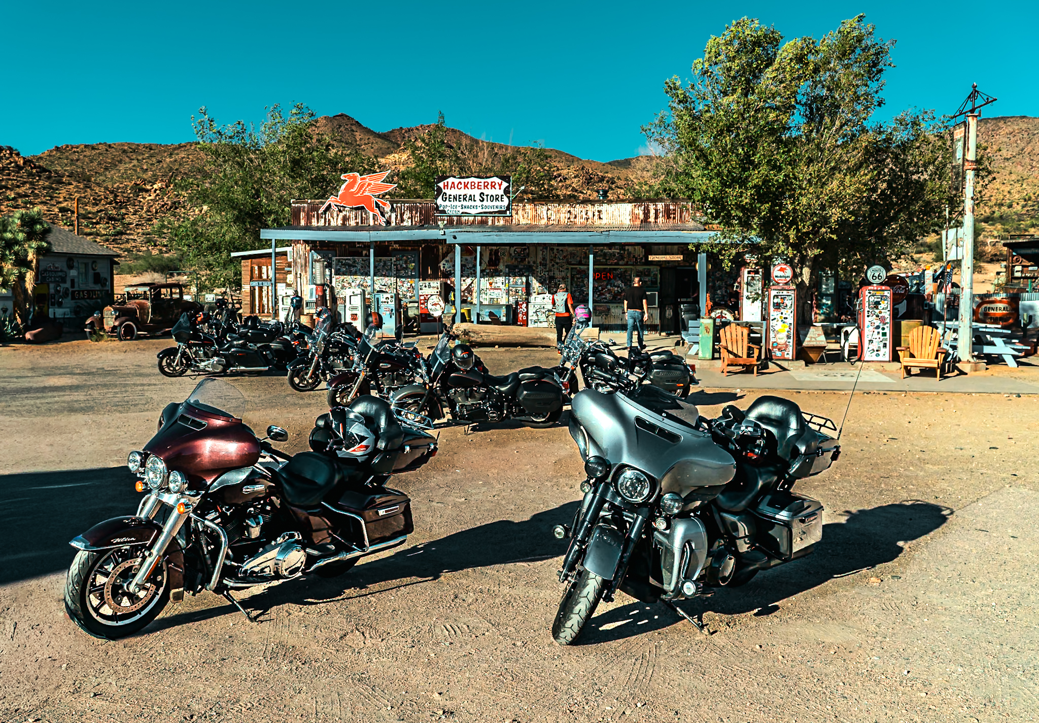 Harley-Davidson motorcycles parked at Hackberry General Store, Route 66 Arizona &mdash; Pegasus sign, vintage pumps, desert mountains