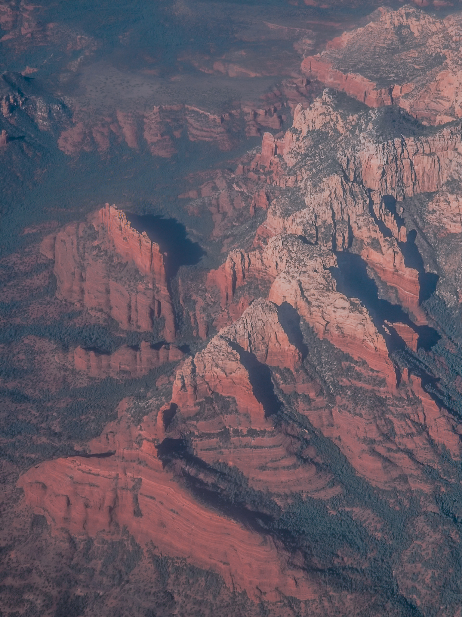 Sedona red rock country at dusk from altitude &mdash; the formations glow in fading light
