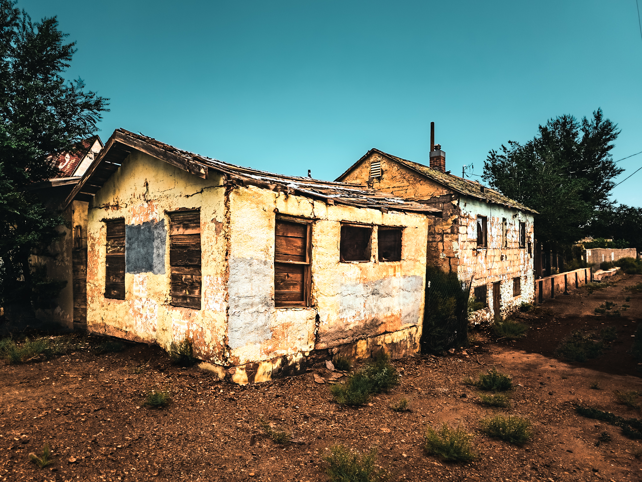 Abandoned Route 66 building in Winslow, Arizona &mdash; warm golden light against a deep teal sky, the ghost of the boom years